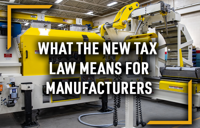 WHAT THE NEW TAX LAW MEANS FOR MANUFACTURERS COE Press Equipment machinery in a manufacturing facility featuring a yellow coil feed line and straightener system, with bold white overlay text reading “What the New Tax Law Means for Manufacturers.”